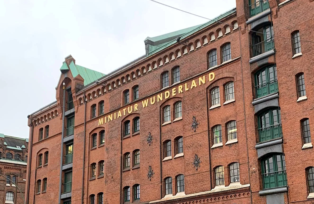 Backsteinfassade eines Speicherstadt-Gebäudes in Hamburg mit dem goldenen Schriftzug „Miniatur Wunderland“.